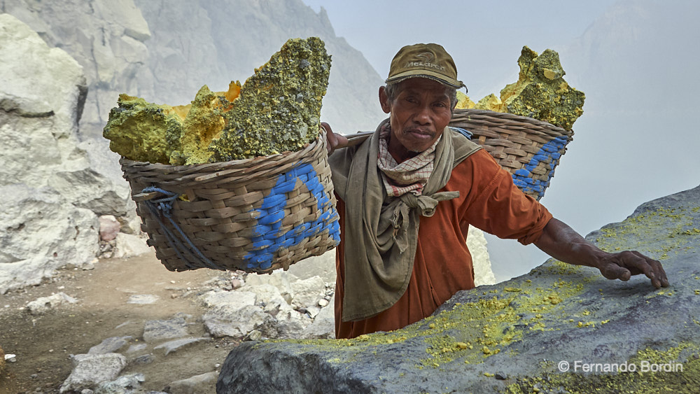 Isola di Java - Indonesia  - Island of Java, Indonesia, land of majestic and imposing volcanoes. Extraordinary protagonists of the force of nature that man has been challenging for a long time. 
In a hellish environment, night and day, fearless "warriors" extract from the IJEN volcano, part of the precious treasure that flows from its bowels, 
pure sulfur ... the devil's gold. (2018)